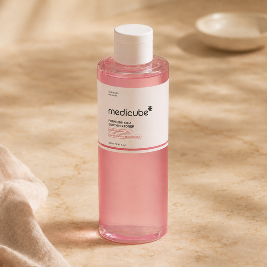Pink skincare bottle with white cap on a beige background